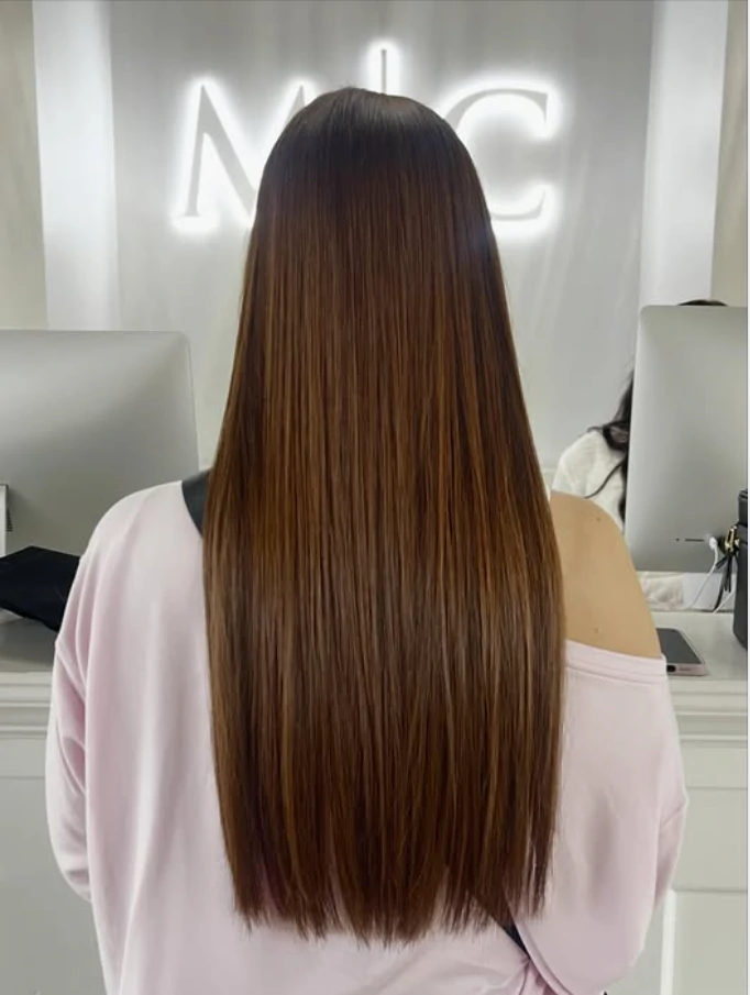 Finished long brunette hair extensions with a smooth blended appearance showcased by Michele Coulter Salon